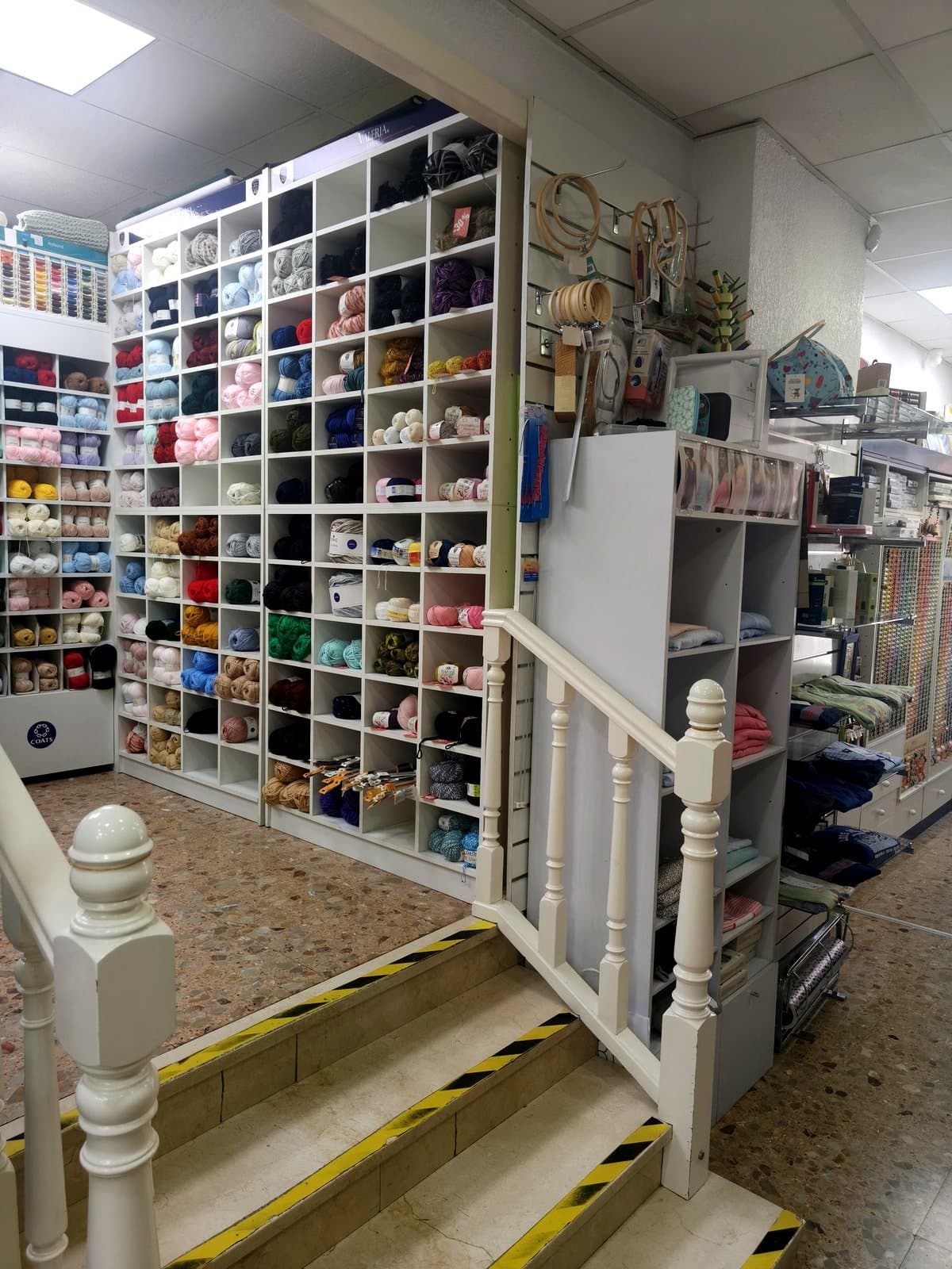 Estantería de lanas ordenadas por colores en el interior de Mercería Marieta