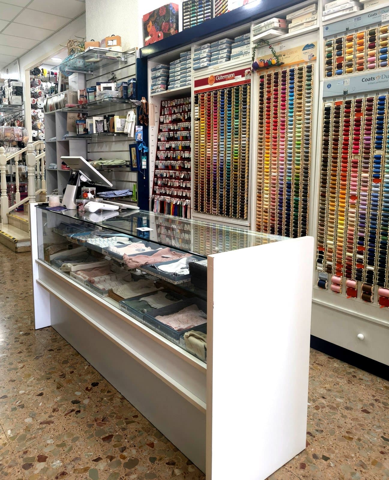 Pared de hilos Gütermann y Coats sobre el mostrador de Mercería Marieta